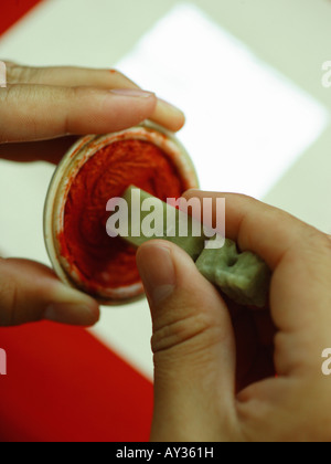 Close-up of a person's hand pressing a seal on an ink pad Stock Photo