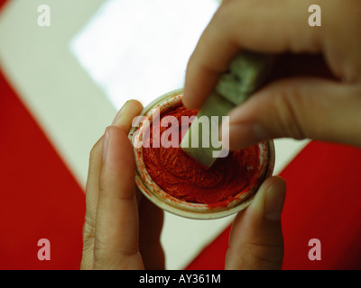 Close-up of a person's hand pressing a seal on an ink pad Stock Photo