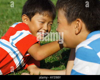 Two boys arm wrestling and smiling Stock Photo