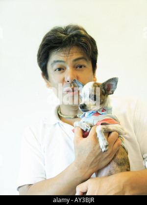 Portrait of a mid adult man carrying a Chihuahua puppy Stock Photo