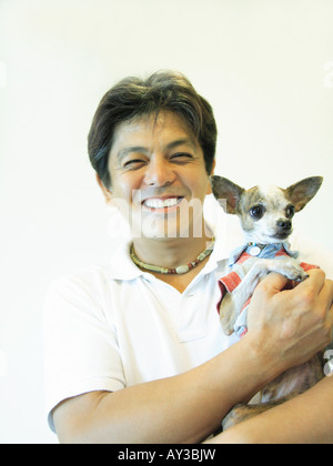 Portrait of a mid adult man carrying a Chihuahua puppy Stock Photo