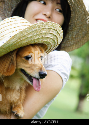 Close-up of a mature woman holding a dog and smiling Stock Photo