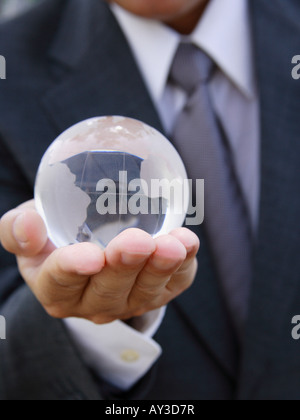 Mid section view of a businessman holding a transparent globe Stock Photo
