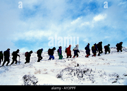 Walkers on snow covered hillside in Highland, Scotland, UK Stock Photo