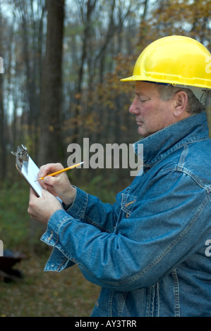 contractor handyman builder smiling confident happy on the job writing estimate Stock Photo