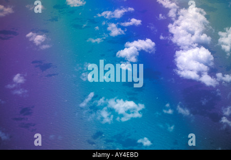 Airplane window view with clouds and sun shining on sea from 30 000 feet Stock Photo