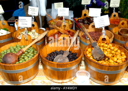 Stall with black and olives marinated in chilly dill olive oil garlic kalamata artichoke hearts harissa & sun dried tomato wood wooden bowls ladles Stock Photo