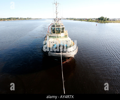 Tugboat with line attached, pulling out of harbor Stock Photo