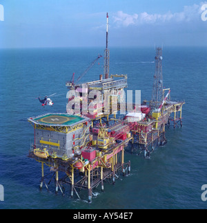 Service helicopter landing on aluminium landing pad at a gas production rig in North Sea Stock Photo