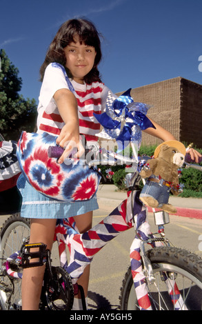 A patriotic girl rides her decorated bicycle, in the 4th of July parade in Capitan, New Mexico. Stock Photo