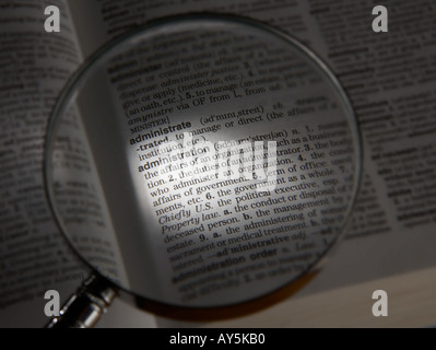 MAGNIFYING GLASS ON DICTIONARY PAGE SHOWING DEFINITION OF THE WORD ADMINISTRATION Stock Photo