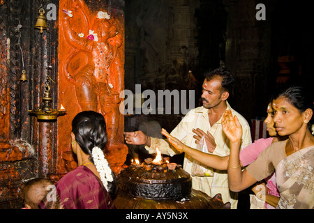 Worshipers standing beside a shrine, Meenakshi Temple, Madurai, Tamil Nadu, India Stock Photo