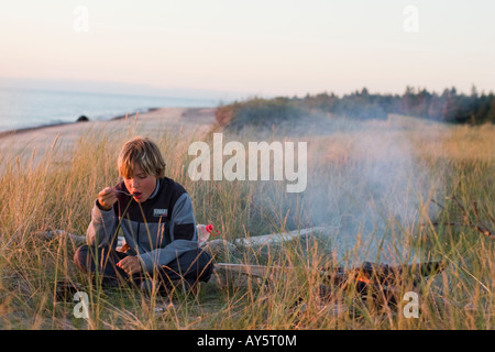 Blond boy camping, Kurzeme, Baltic Sea, Latvia Stock Photo