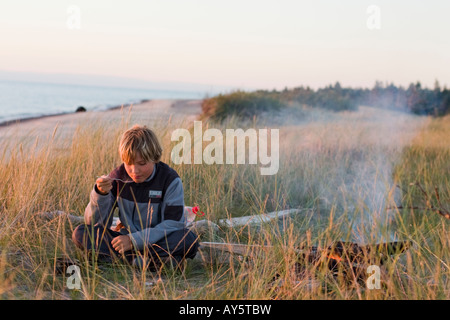 Blond boy camping, Kurzeme, Baltic Sea, Latvia Stock Photo