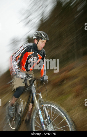 A blurred effect shot of a cross country mountain biker rides his mountain bike along a track Stock Photo