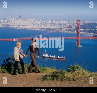 young couple walking near Golden Gate Bridge in San Francisco California USA Stock Photo