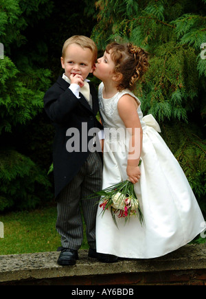 Bridesmaid holding bouquet of flowers Kisses Page Boy during Wedding Celebrations Stock Photo