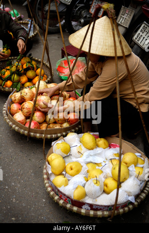 Female street vendor selling fresh fruit, Outside Dong Xuan market, Old Quarter, Hanoi, Vietnam Stock Photo