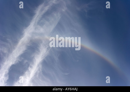Atmospheric halo or arc, a rainbow like variation high up in cirrus clouds caused by refraction of sunlight through ice crystals Stock Photo