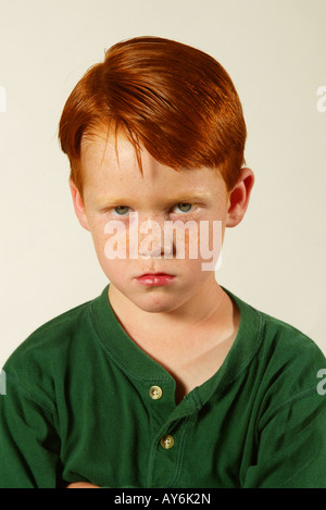 A sad 5 year old red headed Caucasian boy in a green shirt from Southern California MODEL RELEASE Stock Photo