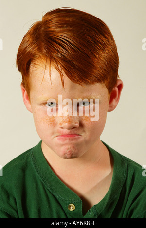 An angry 5 year old red headed Caucasian boy in a green shirt from Southern California MODEL RELEASE Stock Photo