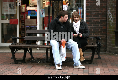 typical british couple sitting on a bench, having a break from shopping Stock Photo