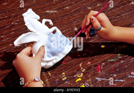 MR 557 Cameron Rogers applies paint to a plaster art  piece, at the annual Mayfair celebration in Cloudcroft, New  Mexico. Stock Photo