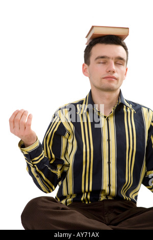 Man in yoga pose with a book on his head Stock Photo