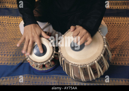 Closeup both hands of Indian classical music maestro Ustad Zakir Hussain playing percussion musical instrument tabla in concert Stock Photo