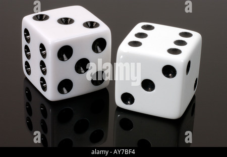 a pair of white dice on black acrylic Stock Photo