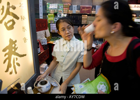European woman is tasting tea in the WUYUTAI Tea Shop in Beijing Stock Photo