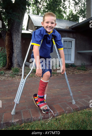 This young man doesn't let a colorful leg cast or crutches slow him down, at Fine Art Days in  Lincoln, New Mexico. Stock Photo