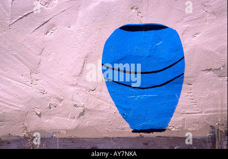 An old painting of a blue pot decorates this adobe wall in White Oaks, Lincoln County, New Mexico. Stock Photo