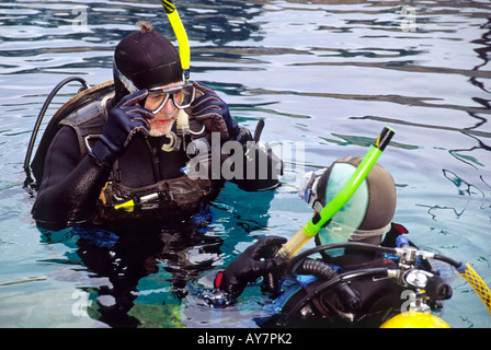 A diving instructor supervises a student during scuba school, at the Blue Hole in Santa Rosa, New Mexico. Stock Photo