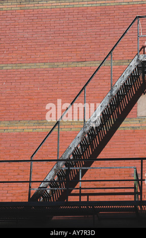 Metal stair case for fire escape attached to ered brick building from side view, Stock Photo