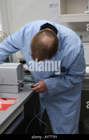 A computer technician working on connecting a device in laboratory Stock Photo