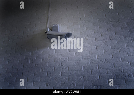 CCTV video camera on white brick wall surveillance Stock Photo