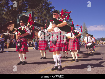 Men in red tartan kilts play bagpipes at the Aspenfest Parade, in downtown Ruidoso, New  Mexico. Stock Photo