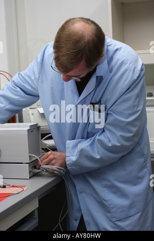 A computer technician working on connecting a device in laboratory Stock Photo
