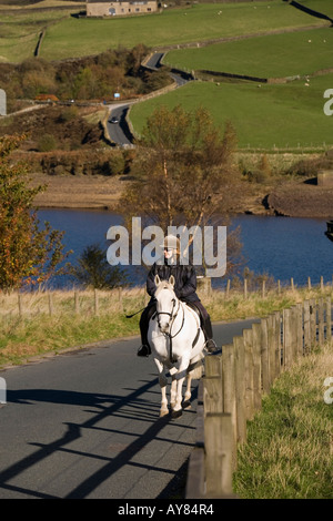 UK Yorkshire Holmfirth woman riding horse over Digley Reservoir dam Stock Photo