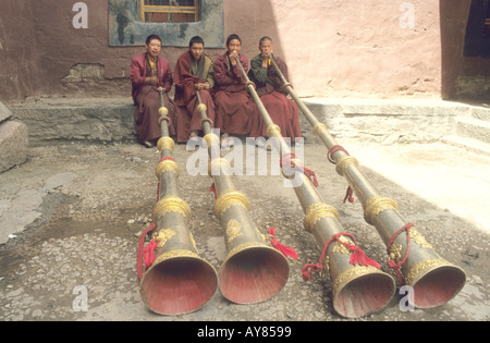 Monks playing the long horns Dung outside Tibetan monastery Stock Photo