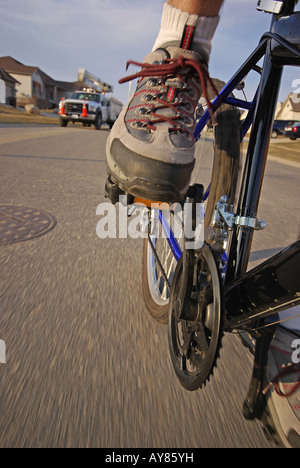 Low angle view of speeding cyclist foot on suburban street Stock Photo