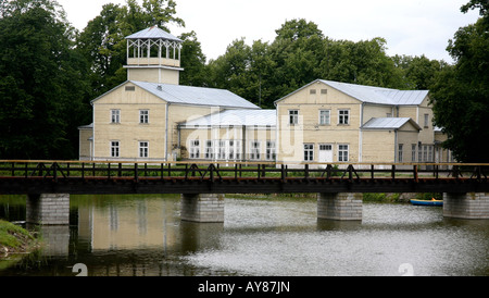 Large wooden buildings with wooden bridge in foreground.  Reflections of buildings in the water, trees as backdrop Stock Photo