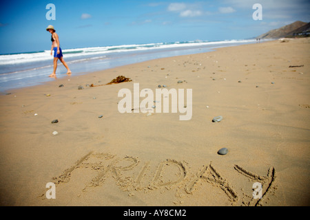 the word friday drawn in the sand with person on the beach ready for the weekend Stock Photo