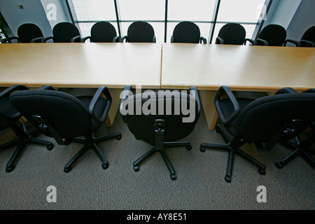 Rows of empty conference room chairs in highrise office building Stock Photo