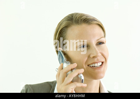 Businesswoman using cell phone, smiling, close-up