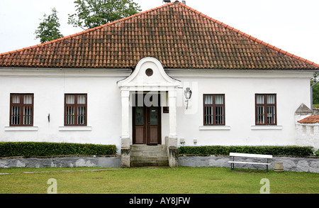 White house with red tile roof, windows on either side. Stock Photo