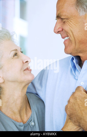 Mature couple smiling at each other, holding hands, close-up Stock Photo