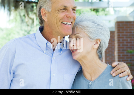 Mature couple embracing, woman's eyes closed, both smiling Stock Photo