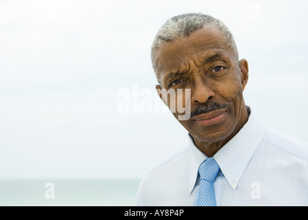 Businessman, looking at camera, sea in background Stock Photo